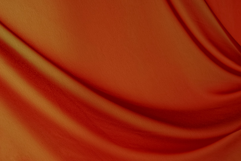 豊かなドレープのあるオレンジ色の布の写真画像