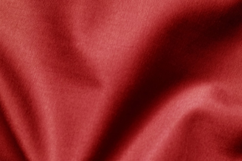 大きなシワのある赤色の生地の写真画像