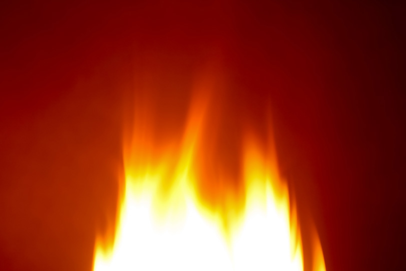 燃え立つ炎が放つ赤い光の写真画像