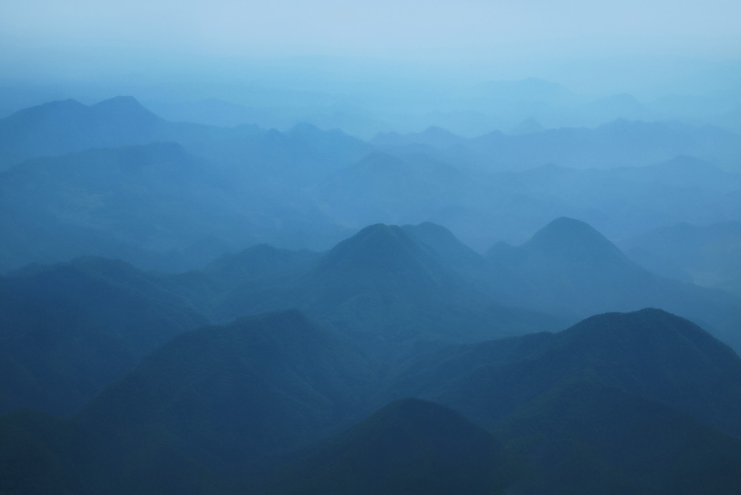 霧で霞んだ水墨画の様な山の風景の写真画像