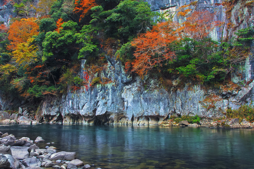 紅葉する渓谷に流れる綺麗な川の写真画像
