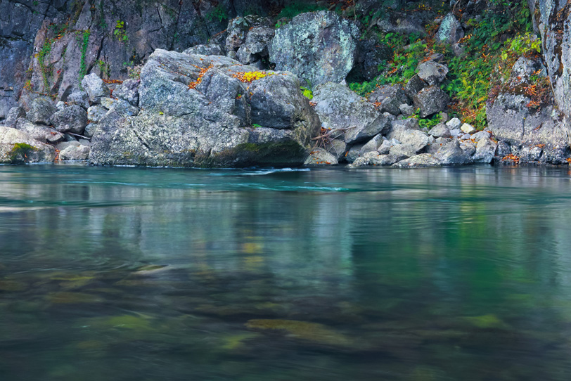 川底が見えるエメラルドグリーンの水と岩の写真画像