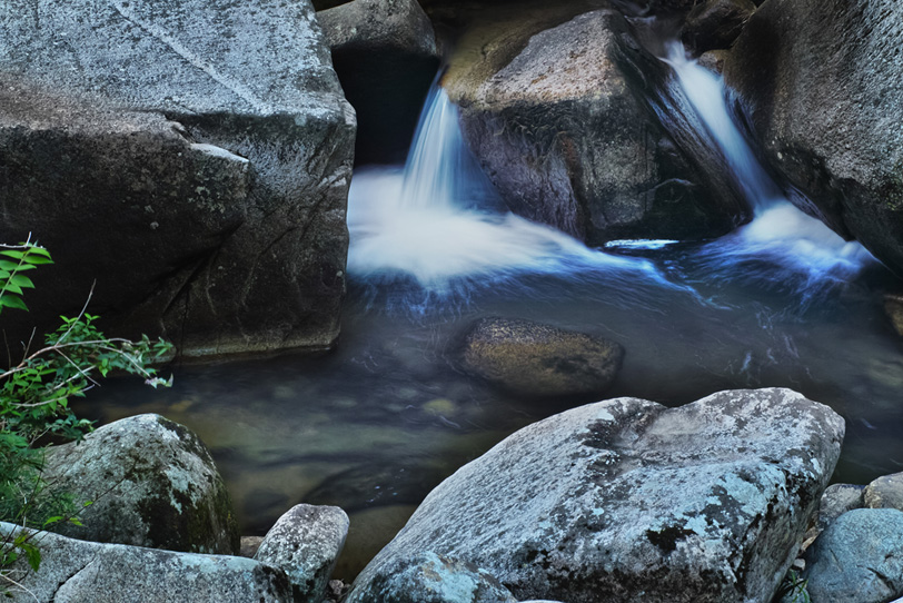渓流の岩の間を流れる水の写真画像