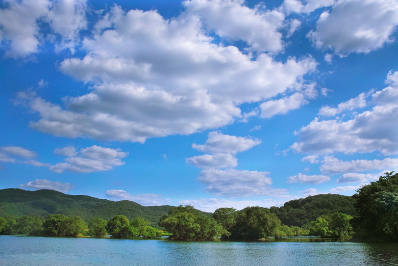 青空を映す穏やかな水面の川の写真画像