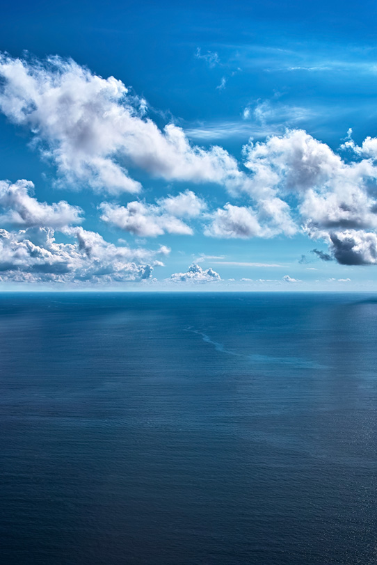 紺碧の海面に映る空と雲の写真画像