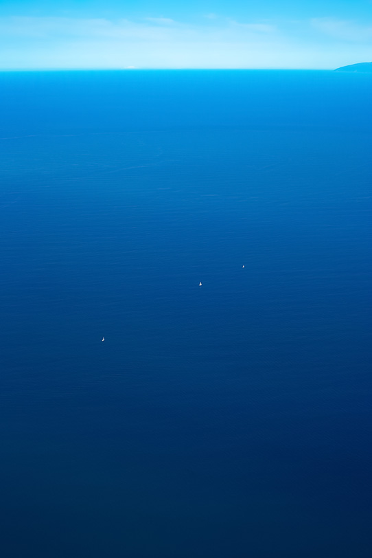 大海に浮かぶ三艇のヨットの写真画像