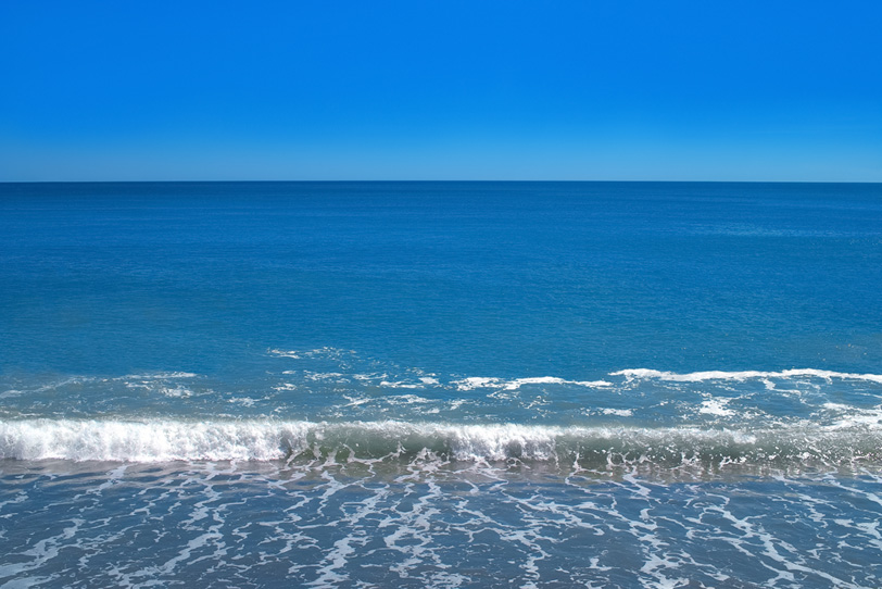 蒼い海の波打ち際の写真画像