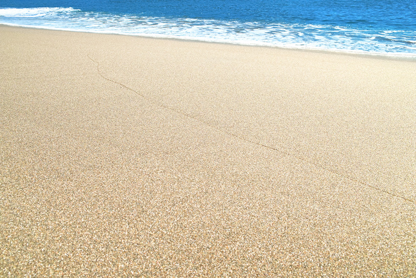 静かな砂浜の波打際の写真画像