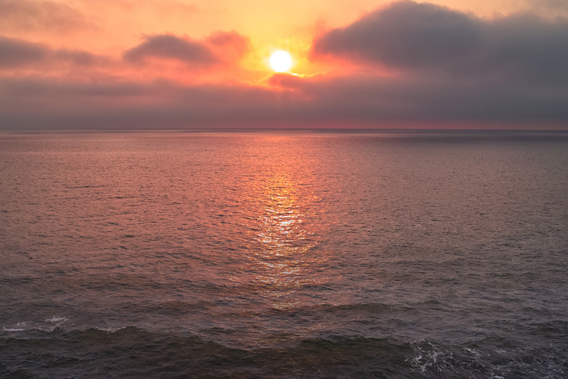 朝日が登る夜明けの海の写真画像