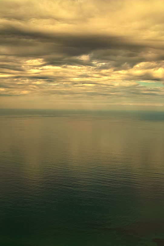 黄金色の雲を写す穏やかな海の写真画像