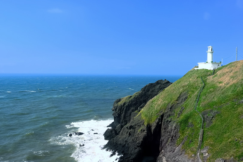 水平線と岬の灯台の写真画像
