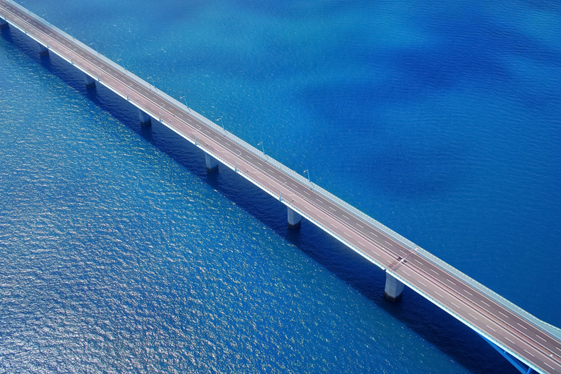 青い海の上に架かる橋の写真画像