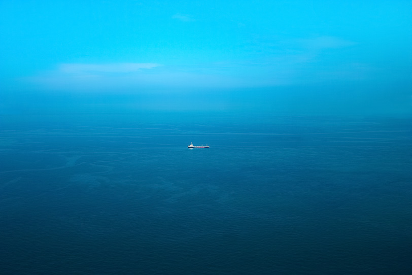 穏やかな海と一隻の船の写真画像