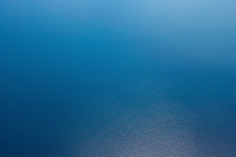 光を反射する紺碧の海の写真画像