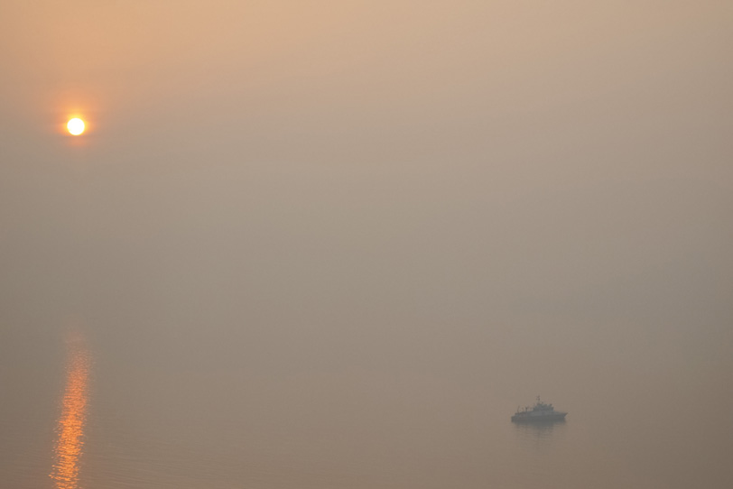 朝焼けの海に浮かぶ船の写真画像