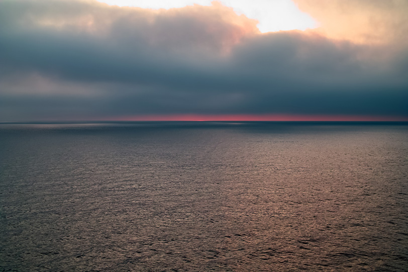 水面が輝く夕暮れの海の写真画像