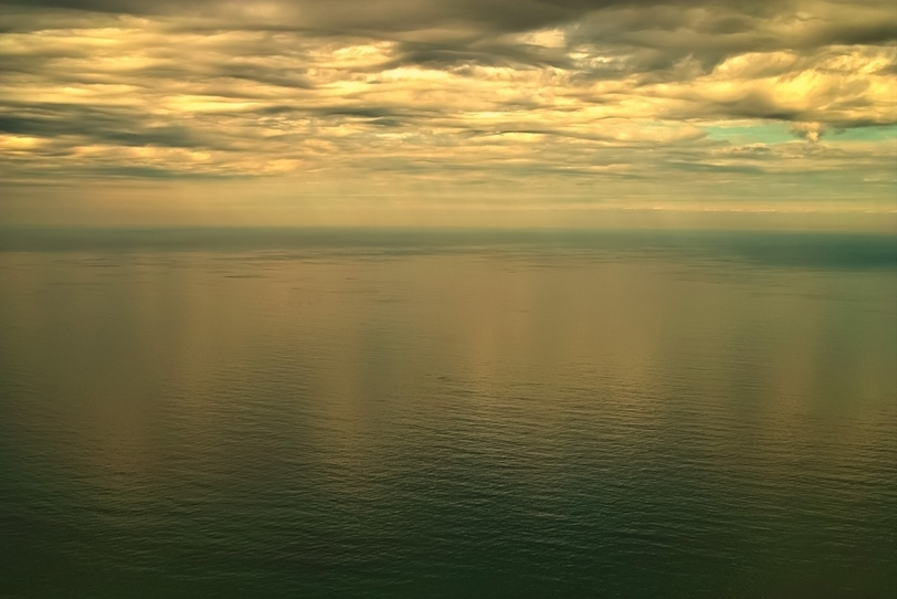 黄金色の空を反射する海の写真画像
