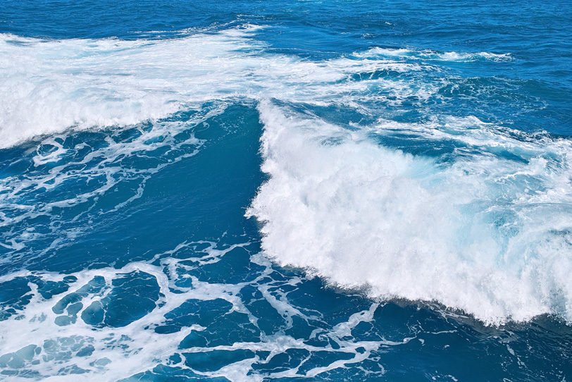 マリンブルーの海に揺れる波の写真画像