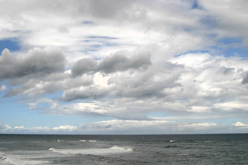 海と雲の多い空の写真画像