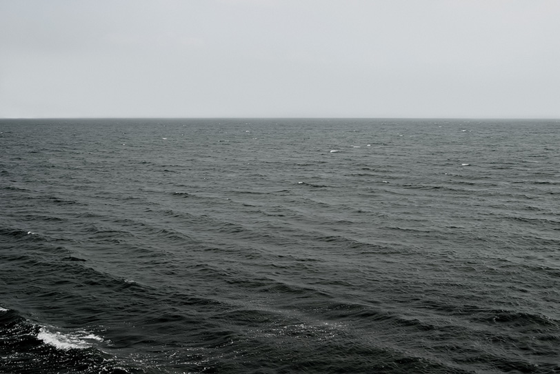 灰色の空と黒い海の写真画像