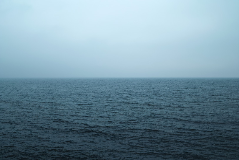 冷たい雨が降る薄暗い海の写真画像