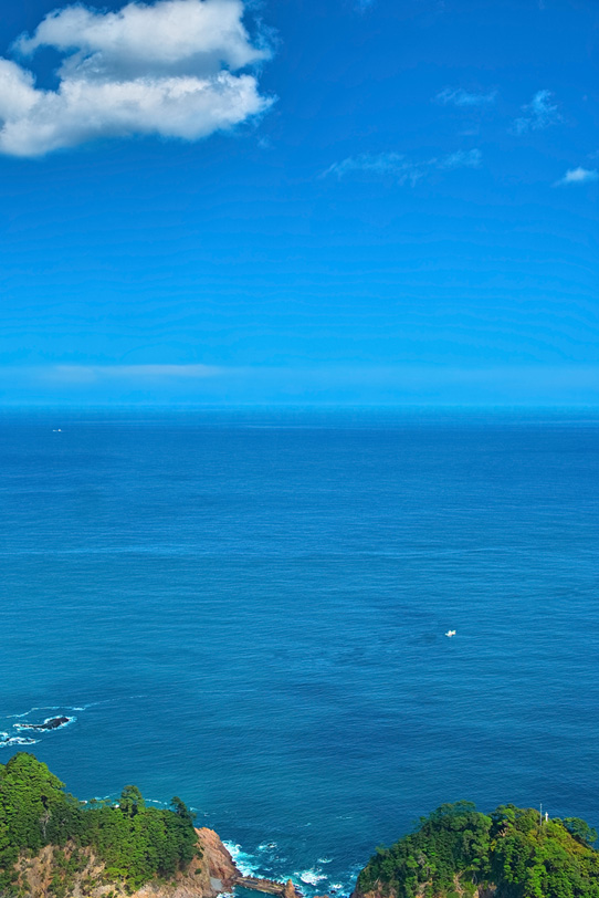 空と海と緑の岬の写真画像