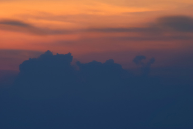 墨色の雲とオレンジ色の夕焼けの写真画像