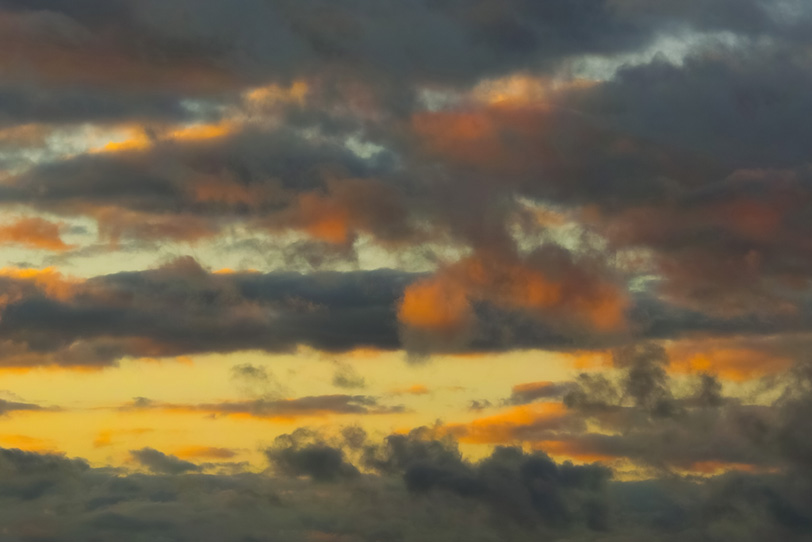 灰色の雲が滲む夕焼けの写真画像