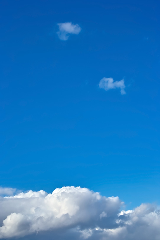 濃紺の青空が厚雲の上に広がるの写真画像