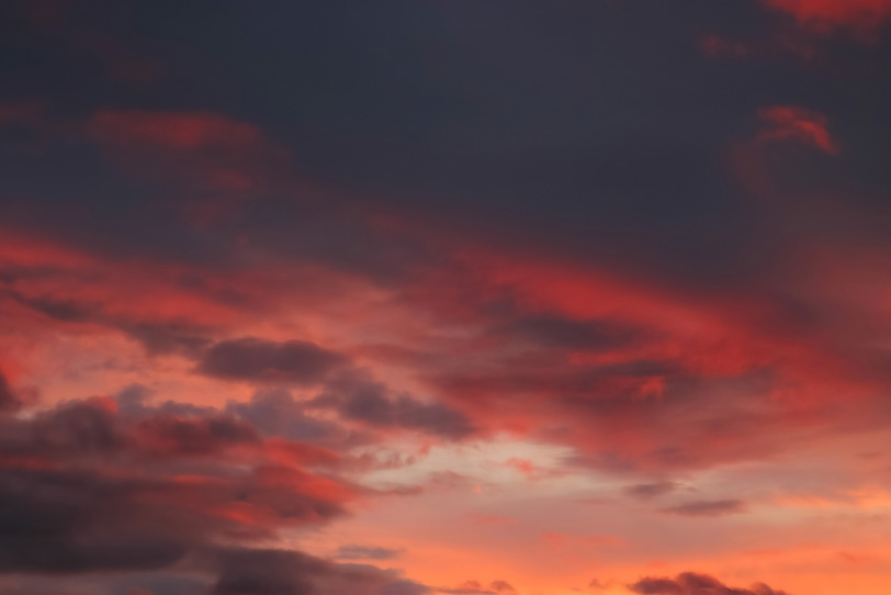夕焼けに黒雲が赤く染まるの写真画像