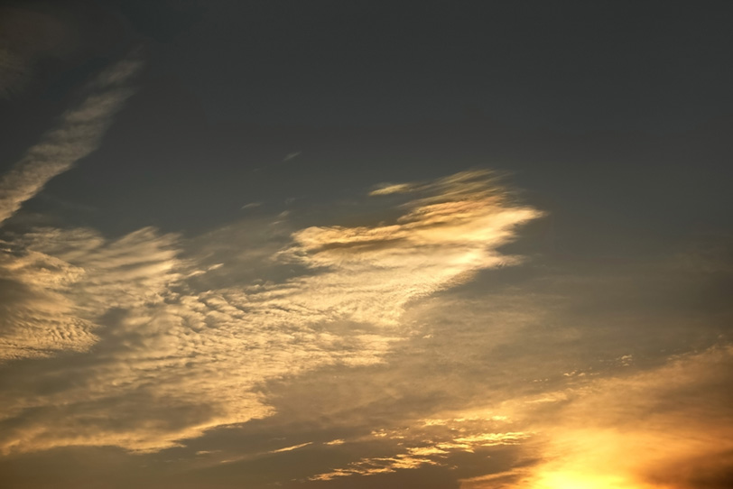 輝く薄雲が夕焼けを映すの写真画像