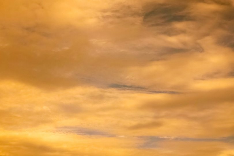 夕焼けに彩られる金色の空の写真画像
