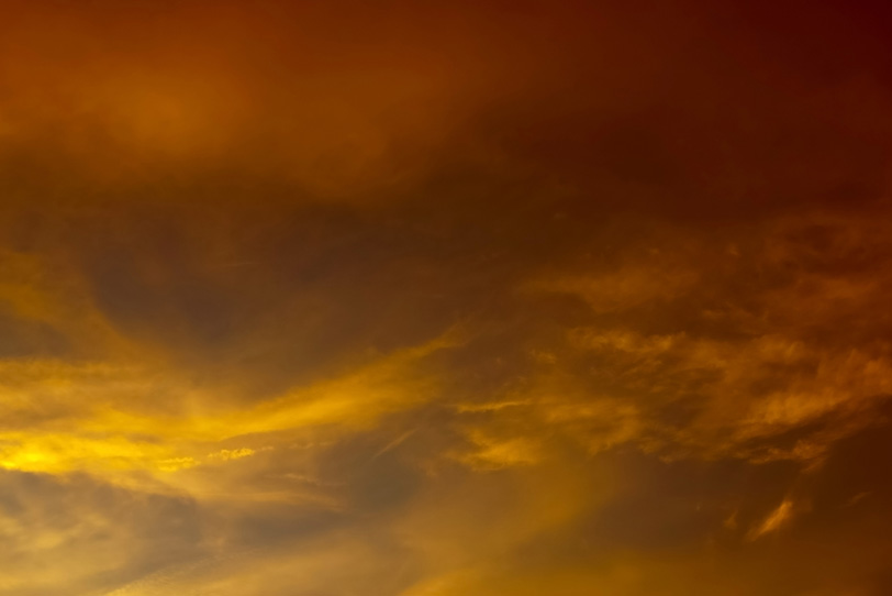 金色の雲が輝く暗い夕焼け空の写真画像