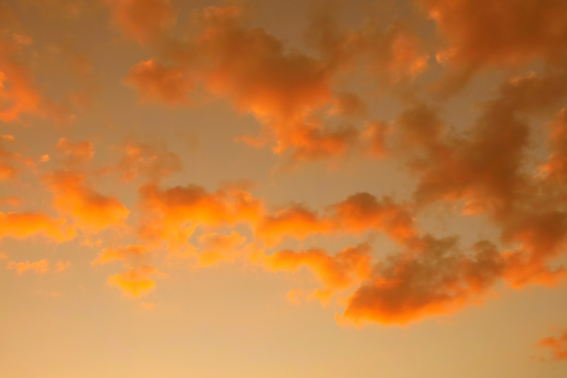 夕焼けの空を飾る橙色の雲の写真画像