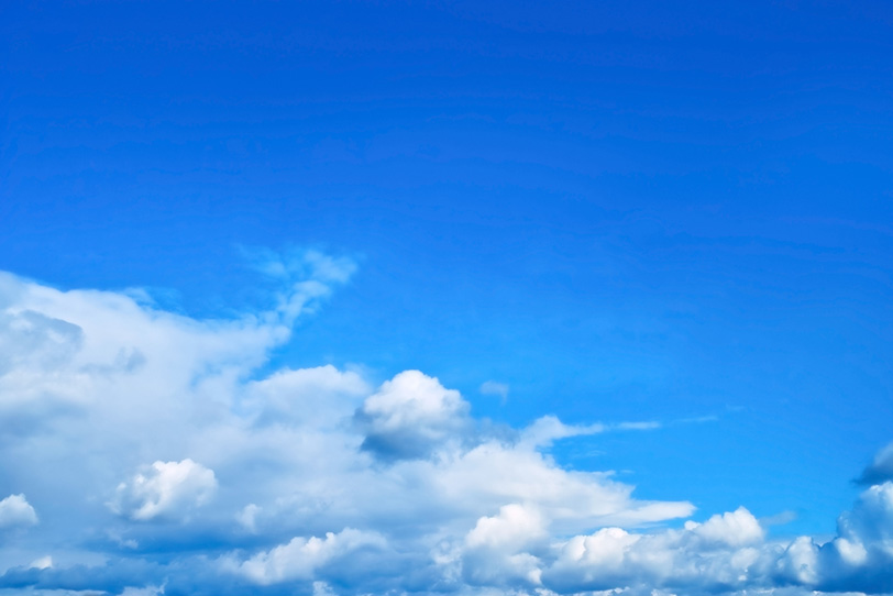 青空の下を這う積雲と濃密雲の写真画像