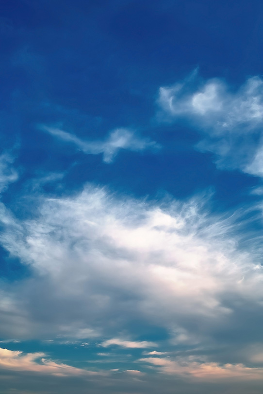 煙の様な大きな雲と暗い青空の写真画像