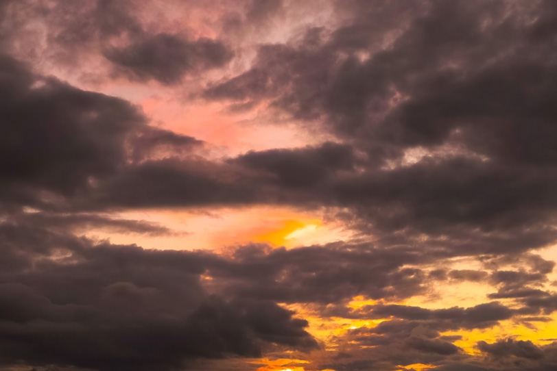 夕焼けの空に黒い雲が覆うの写真画像