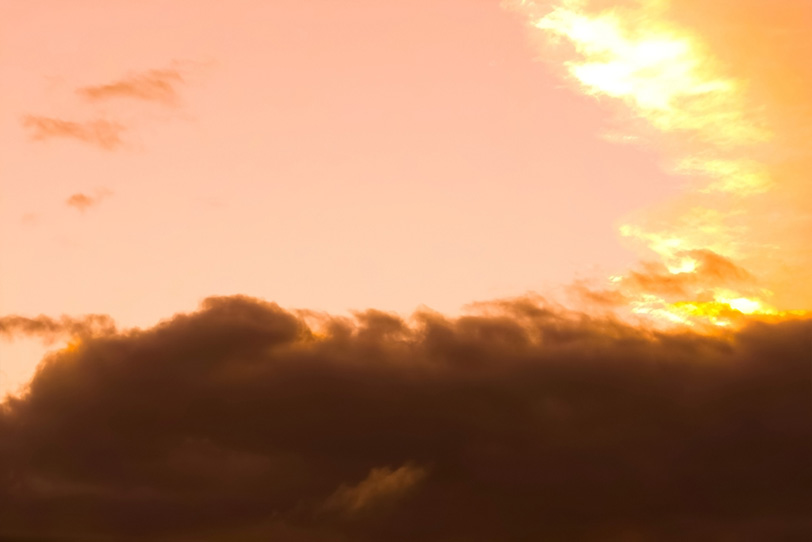 黒雲が壁の様に遮る夕焼けの写真画像