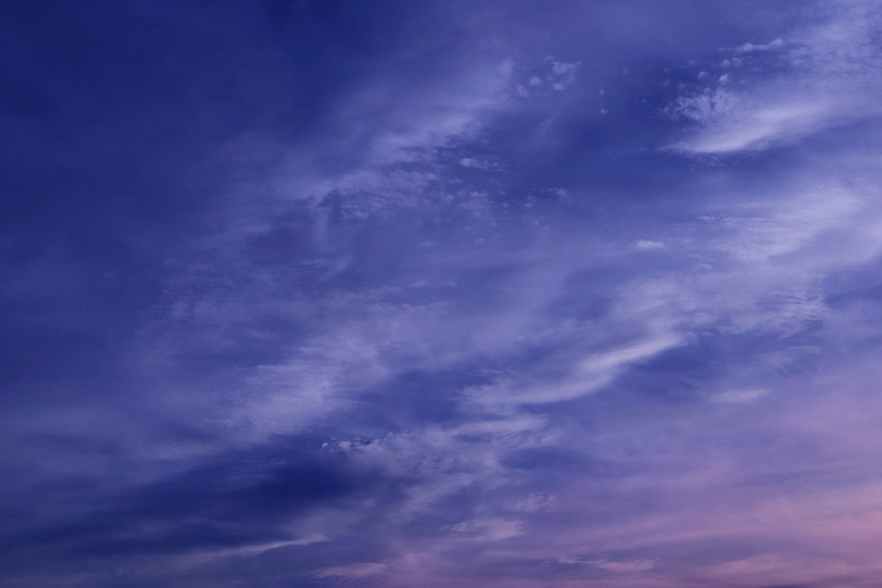 青紫色の雲を夕焼けが染めるの写真画像