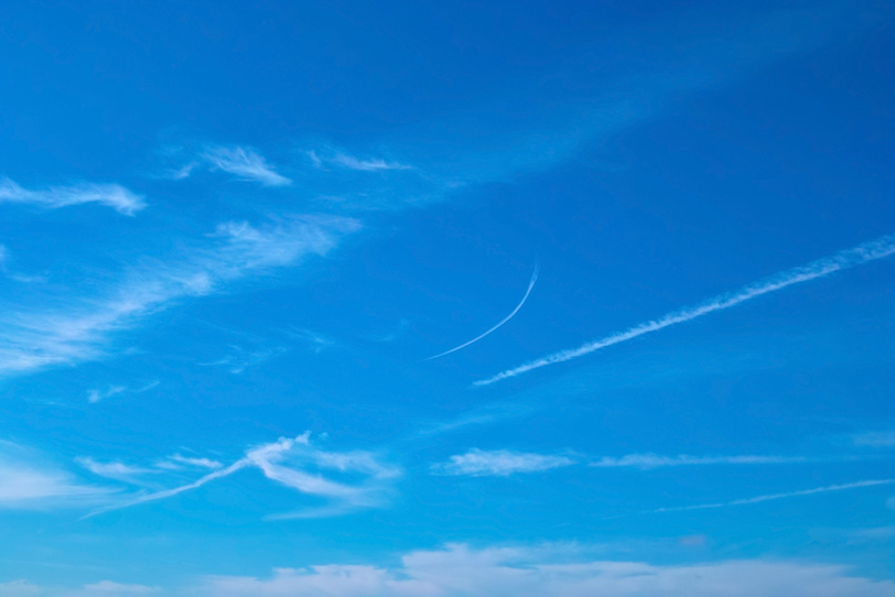 青空に並んで伸びる飛行機雲と巻雲の写真画像