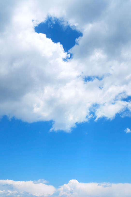 青空に浮かぶ穴の空いた雲の写真画像