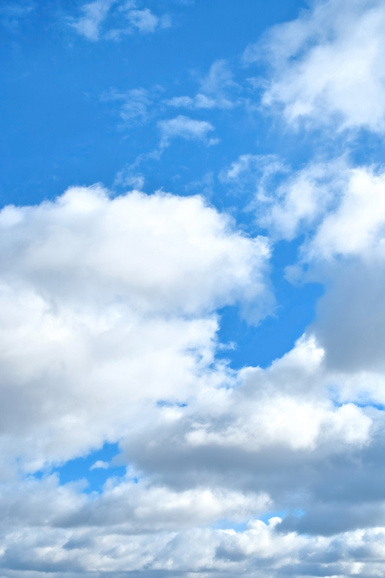青空の下に群れ集う大きな雲の写真画像