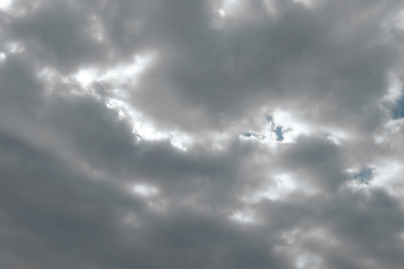 空一面のまだら雲から漏れる光の写真画像