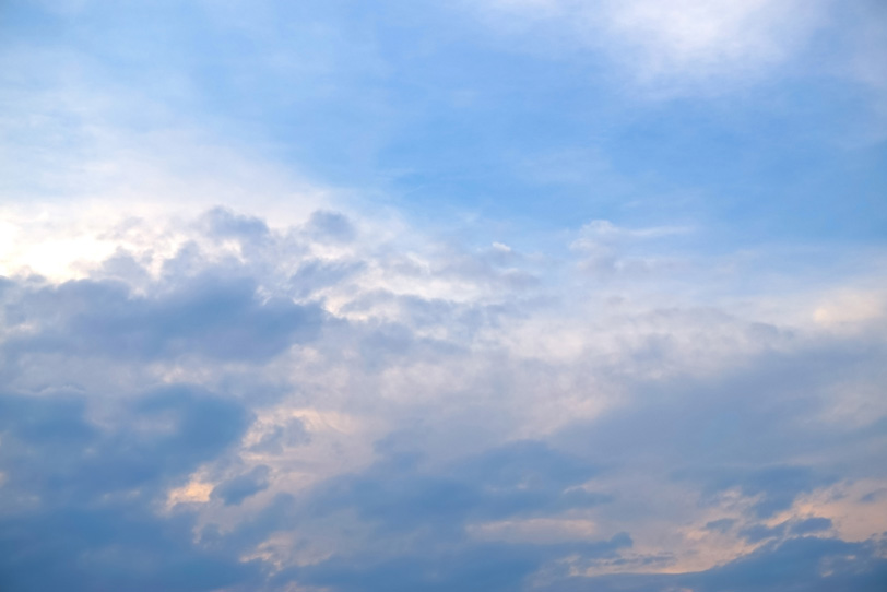 朝焼に淡く染まる雲と青い空の写真画像