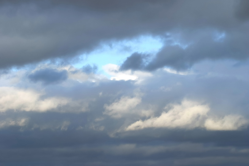 厚い乱層雲に見える僅かな青空の写真画像