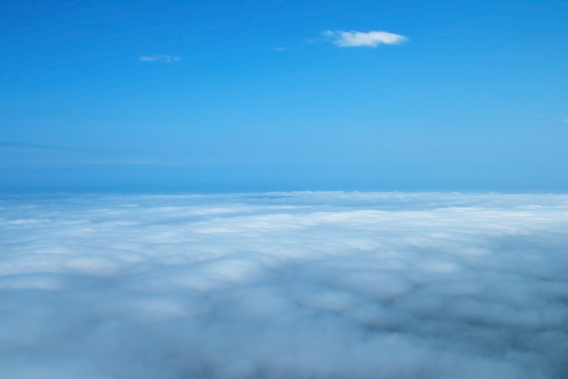 青空の下に雪原の様に広がる雲の写真画像