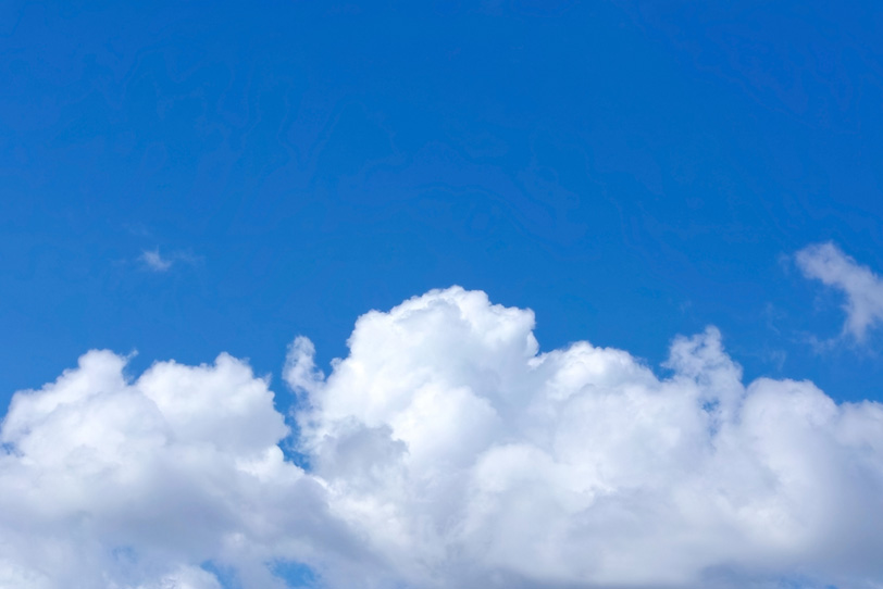 白い雲が横たわる紺色の青空の写真画像