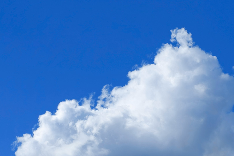 三角雲とベタ塗りの青空の写真画像