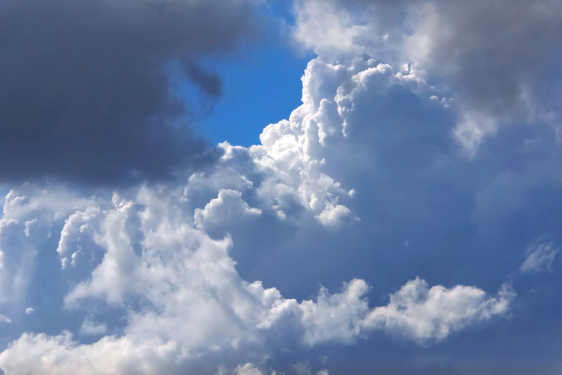 見上げる積乱雲と小さな青空の写真画像