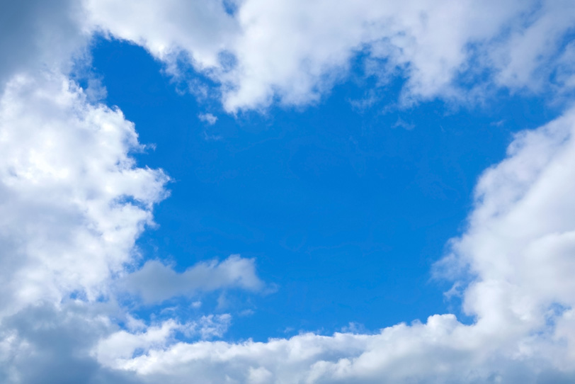雲のフレームが飾る清澄な青空の写真画像